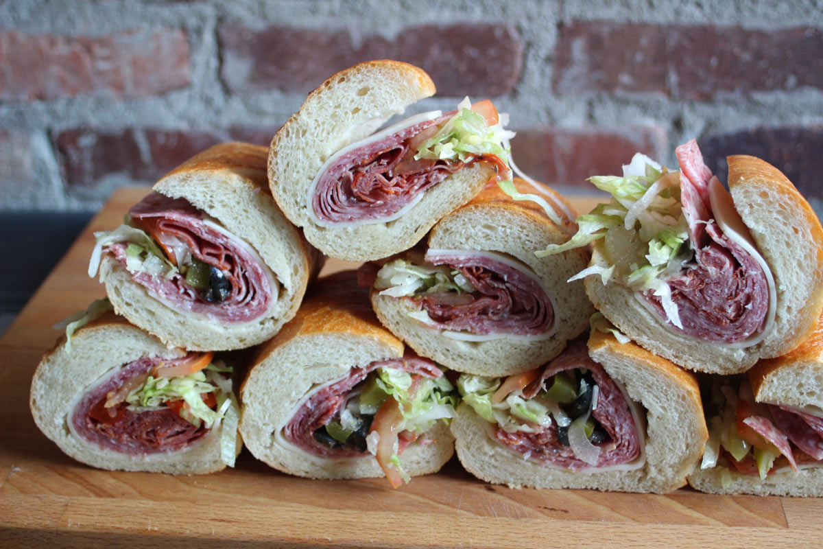 Italian subs from SubCulture Catering: salami, capicola, provolone, olives, onion, lettuce, tomato, house vinaigrette